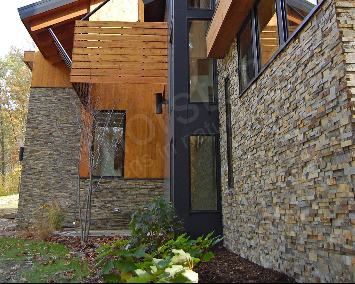 Exterior stacked stone residential project where the stone terminates into a landscaping bed to minimize the appearance of spalling stones